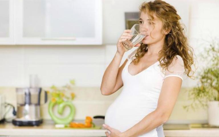 Беременная женщина пьет воду